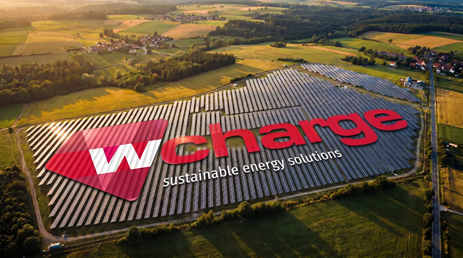 Luftaufnahme eines großen Solarfeldes mit wcharge-Logo in der Landschaft bei Sonnenuntergang